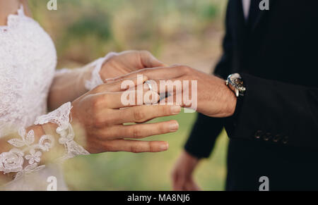 Libre de mettre un anneau de mariage mariée sur le doigt du marié. Wedding couple. Banque D'Images