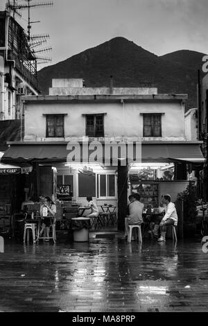 Les gens s'asseoir à une des tables de restaurants sur les marchés du logement de Tai O, Hong Kong Banque D'Images