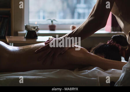 Masseur professionnel Faire Massage tissus profonds huilés pour une fille à massage ayurveda Session Banque D'Images