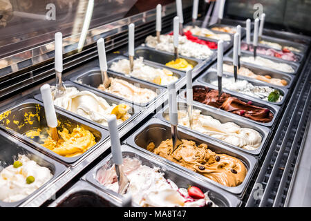 La crème glacée yogourt congelé compteur desservant coloré parlour avec de nombreuses saveurs scoopable, sorbet, chocolat, garnitures, café Banque D'Images