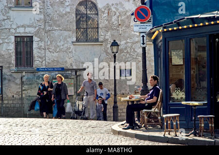 Paris, France. Montmartre. La marche de la famille et de l'homme assis à l'extérieur au café du coin de la Place du Tertre Banque D'Images