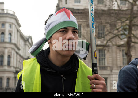 Un jeune homme syrien, portant drapeau syrien sur la tête, s'insurgent contre le régime Assad en dehors de la Downing Street, à Londres, Royaume-Uni. Banque D'Images
