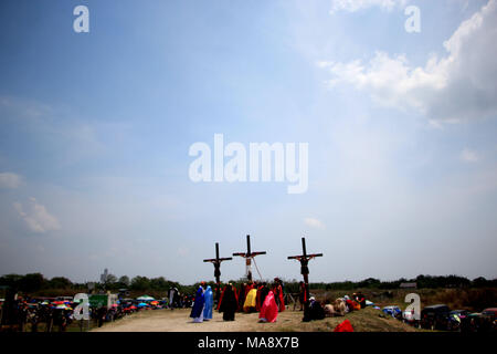 Aux Philippines. 30Th Mar, 2018. Ernaje Ruben, 57 ans effectuée comme Jésus Christ qui était littéralement crucifié sur 32e fois sans anesthésie durant la "Senakulo" (reconstitution de la passion du Christ) à Cutud, San Fernado, Pampanga (province du nord de Manille) le Vendredi saint. Les traditions sont découragés par l'Église catholique aux Philippines, qu'ils considéraient comme les superstitions des vieux catholicisme populaire d'automutilation que sur l'enseignement de l'Eglise. Credit : Gregorio B. Dantes Jr./Pacific Press/Alamy Live News Banque D'Images