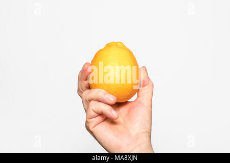 Une orange tenu dans une main Banque D'Images