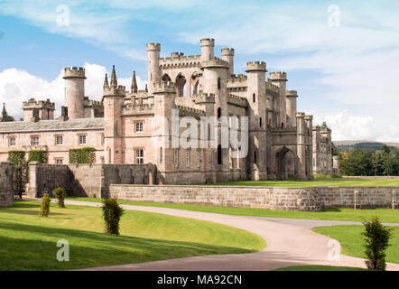 Lowther Castle, Lowther Park, Lake District, Cumbria, England, UK. Château anglais avec entrée en premier plan et le château en arrière-plan. Ciel bleu Banque D'Images