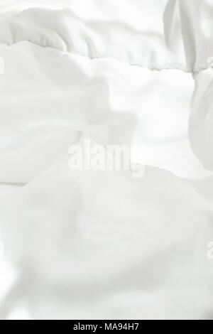 Couverture de coton blanc dans la chambre avec la lumière du soleil du matin lumineux pénétrant par la fenêtre. Met en évidence des fuites. Modèle vierge pour poster bannière. Waki énergie Banque D'Images