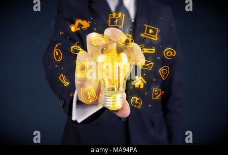 Un bureau commercial promouvoir ses idées de concept avec l'illustration des médias en ligne et les logos de l'appareil autour de l'ampoule en verre électrique. Banque D'Images