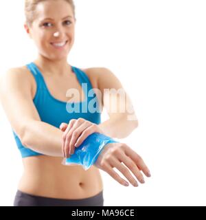 Jeune femme avec poche de glace sur son poignet, studio shot. Banque D'Images