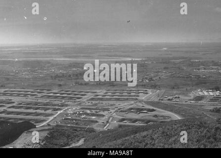 Photographie noir et blanc montrant une vue aérienne, ou une vue tourné à partir d'une colline, sur un paysage de plaine, avec des routes ou pistes d'atterrissage, et plusieurs bâtiments, probablement les casernes du camp de l'US Marine Corps, situé au plan intermédiaire, photographié au Vietnam pendant la guerre du Vietnam (1955-1975), 1968. () Banque D'Images