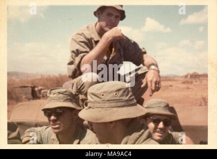 Photographie en couleur de quatre soldats portant des uniformes et des chapeaux, l'un assis en tailleur, au-dessus des trois autres, qui ne sont visibles qu'en très gros plan, photographié au Vietnam pendant la guerre du Vietnam (1955-1975), 1971. () Banque D'Images