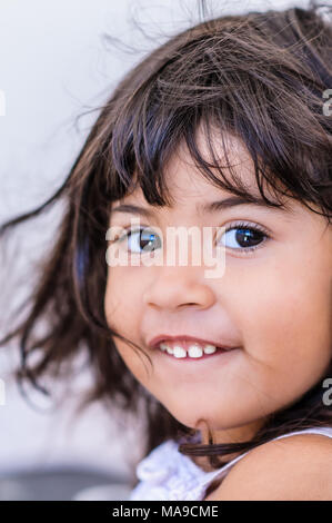 Petite fille à l'école mexicaine smiling with regard sournois et dents dehors Banque D'Images