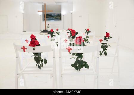 Intérieur de la première église baptiste de Sutherland SPRINGS, TX, est maintenant un mémorial aux 26 membres de la congrégation abattu durant le service en novembre 2017, avec une seule chaise blanche et rose rouge commémorant chaque victime. Banque D'Images