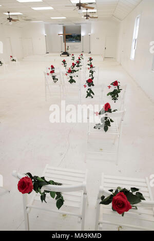 Intérieur de la première église baptiste de Sutherland SPRINGS, TX, est maintenant un mémorial aux 26 membres de la congrégation abattu durant le service en novembre 2017, avec une seule chaise blanche et rose rouge commémorant chaque victime. Banque D'Images