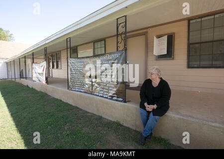 Cinq mois après la fusillade qui a coûté la vie à 26 First Baptist Church de Sutherland Springs, une femme assise à côté d'une bannière avec le nom de chaque victime pendaison à l'église rurale. Banque D'Images