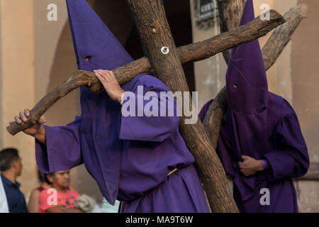 Queretaro, Mexique, 31 Mar 2018. Pénitents cagoulés procéder croix de bois qu'ils commencent la Procession du Silence dans les rues le vendredi saint pendant la Semaine Sainte, le 30 mars 2018, à Querétaro, au Mexique. Les pénitents, connu sous le nom de Nazaréens, supporter la lourde croix et chaînes d'entraînement à 4 heures d'mars en mémoire de la passion du Christ. Credit : Planetpix/Alamy Live News Banque D'Images