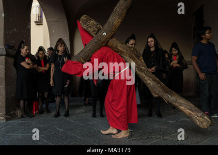 Queretaro, Mexique, 31 Mar 2018. Pénitents cagoulés procéder croix de bois qu'ils commencent la Procession du Silence dans les rues le vendredi saint pendant la Semaine Sainte, le 30 mars 2018, à Querétaro, au Mexique. Les pénitents, connu sous le nom de Nazaréens, supporter la lourde croix et chaînes d'entraînement à 4 heures d'mars en mémoire de la passion du Christ. Credit : Planetpix/Alamy Live News Banque D'Images