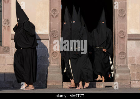 Queretaro, Mexique, 31 Mar 2018. Pénitents cagoulés sortent de l'église de la Sainte Croix au début de la Procession du Silence dans le cadre de la Semaine Sainte 30 mars 2018, à Querétaro, au Mexique. Les pénitents, connu sous le nom de Nazaréens, portant de lourdes croix et chaînes d'entraînement à 4 heures d'mars à recréer la douleur et les souffrances au cours de la passion du Christ. Credit : Planetpix/Alamy Live News Banque D'Images