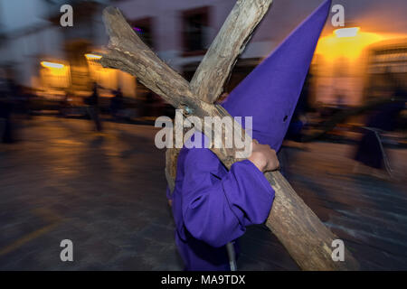 Queretaro, Mexique, 31 Mar 2018. Un pénitent à capuchon porte une lourde croix de bois à travers les rues de la ville pendant la Procession du Silence dans le cadre de la Semaine Sainte 30 mars 2018, à Querétaro, au Mexique. Les pénitents, connu sous le nom de Nazaréens, portant de lourdes croix et chaînes d'entraînement à 4 heures d'mars à recréer la douleur et les souffrances au cours de la passion du Christ. Credit : Planetpix/Alamy Live News Banque D'Images