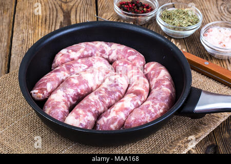 Les saucisses dans la poêle rustique. Studio Photo Banque D'Images