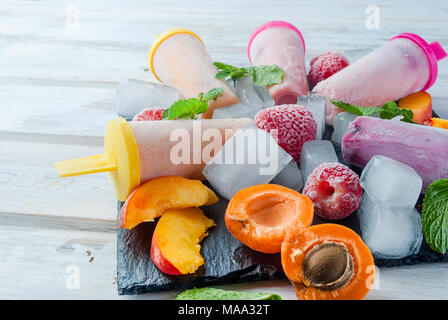 Glace Maison de baies. L'été froid dessert de pâte d'abricots surgelés, pêches, groseilles, fraises, bleuets avec de la glace et des fruits sur bla Banque D'Images