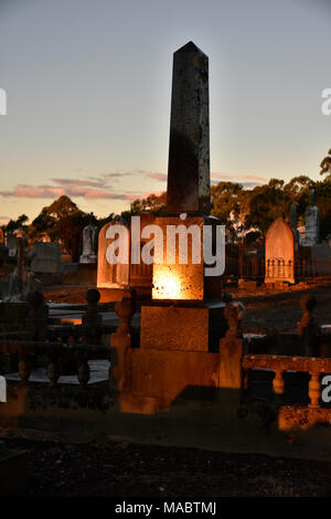 Coucher du soleil refected off clack en pierre tombale dans le cimetière de Glen Innes en Nouvelle Galles du Sud en Australie Banque D'Images