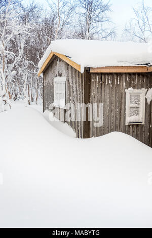 Chalet couvert de neige dans un village sami en Laponie suédoise Banque D'Images