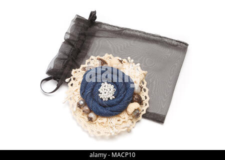 Broche fait main ayant la forme de la fleur faite de tissu denim dentelle blanche sur Banque D'Images