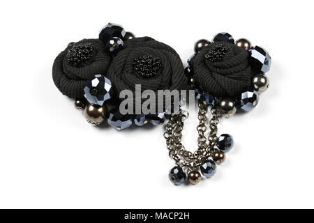 Broche d'artisanat, pendentif en forme de fleurs noir à partir de tissus et de perles à facettes noires, reliée par une chaîne Banque D'Images