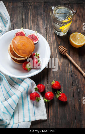 Tasse de thé et des pancakes aux figues, fraises sur plaque blanche libre. Banque D'Images