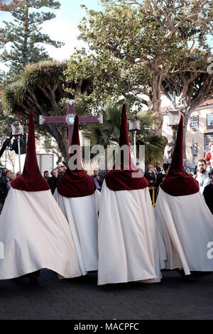 Vue arrière de pénitents qui marche avec peignoirs solennellement dans 'La grande procession de la Semaine Sainte, à Pâques à La Laguna, Tenerife, Canary Islands Banque D'Images