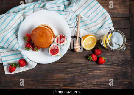 Tasse de thé et des pancakes aux figues, fraises sur plaque blanche libre. Banque D'Images