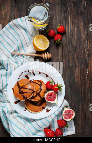 Tasse de thé et des pancakes aux figues, fraises sur plaque blanche libre. Banque D'Images