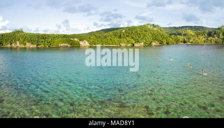 Une antenne panorama de quatre personnes sur le stand-up paddle boards sur une journée calme dans la baie de piti, Guam, Micronésie, Îles Mariannes, Océan Pacifique. Banque D'Images