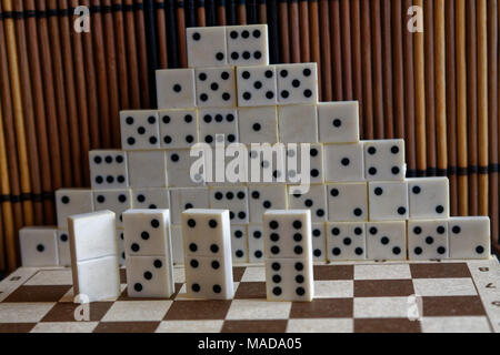 Pyramide de pièces domino sur la table en bois bambou brown background Banque D'Images