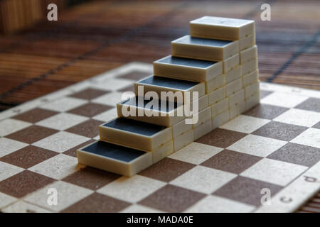 Pyramide de pièces domino sur la table en bois bambou brown background Banque D'Images