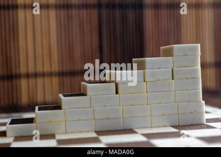 Pyramide de pièces domino sur la table en bois bambou brown background Banque D'Images