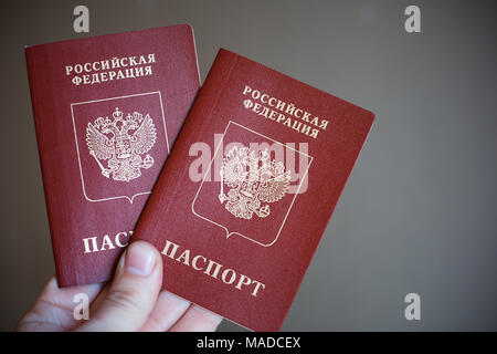 Deux passeports russes dans la main. Document officiel russe sur fond noir Banque D'Images