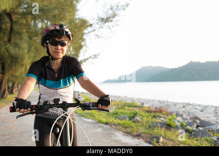 Joyeux senior woman riding a bicycle Banque D'Images