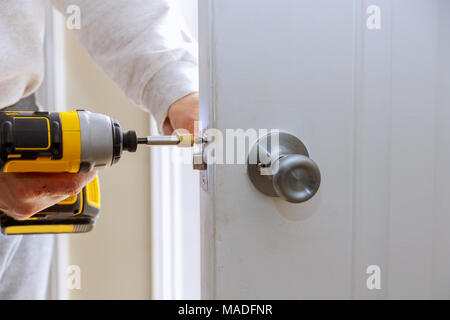 L'installation de verrous sur la porte mains réparation d'une serrure de porte à l'aide d'un tournevis Banque D'Images