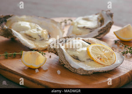 Des huîtres en coquille avec du citron on cutting board Banque D'Images