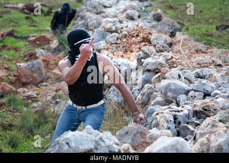 Bil'in, Palestine, 7 janvier 2011 : jeunes hommes palestiniens est montrant un doigt moyen au cours d'une manifestation contre la présence israélienne en Cisjordanie. Banque D'Images