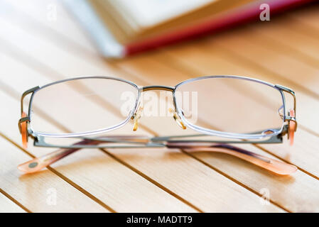 Lunettes et livre ouvert sur une table en bois fermer Banque D'Images