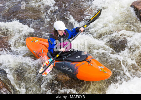Groupe d'adolescents de la formation dans des kayaks à Etive River Falls, Glencoe, Highlands, Scotland, UK en mars - kayakiste unique Banque D'Images