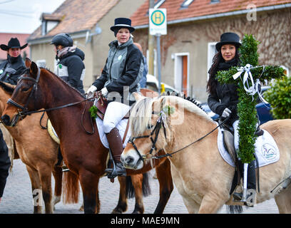 01 avril 2018, l'Allemagne, l'Ragow : Pâques rider Steffi Blaschke sur son cheval tenant une croix en hêtre des branches d'arbre dans la ville de Spreewald Ragow bei Luebbenau le dimanche de Pâques. Circonscription de Pâques se fait avant tout dans les zones d'implantation sorabe dans la Lausitz. En tenue de fête les cavaliers et leurs chevaux décorés prendre part tous les ans le dimanche de Pâques à la traditionnelle procession de Pâques répandre la Bonne Nouvelle de Jésus la résurrection du Christ avec des chants et des prières. Photo : Patrick Pleul/dpa-Zentralbild/ZB : dpa Crédit photo alliance/Alamy Live News Banque D'Images