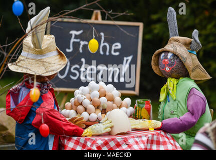 01 avril 2018, l'Allemagne, l'Ragow : 'Joyeuses Pâques' est écrit sur un panneau derrière un couple de lapins de Pâques le dimanche de Pâques. Les décorations sont mis dans un jardin en Ragow bei Luebbenau. Photo : Patrick Pleul/dpa-Zentralbild/ZB : dpa Crédit photo alliance/Alamy Live News Banque D'Images