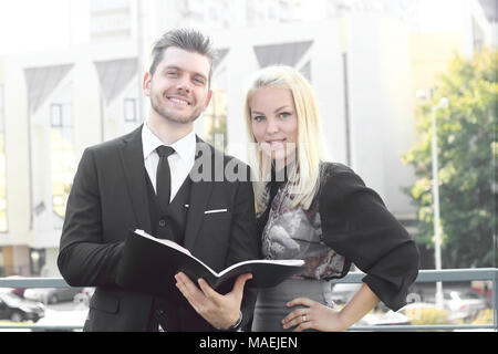 Couple d'employés à lire des documents, debout près de l'office Banque D'Images