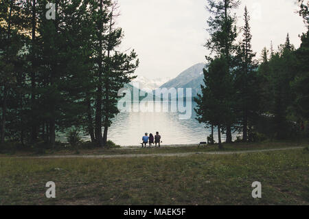 Les touristes s'asseoir sur un banc au bord de l'Alpine Lake Banque D'Images