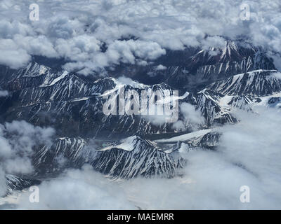 Les chaînes de montagnes sont élevés avec des sommets enneigés au milieu de nuages, en diagonale sur la photo. Banque D'Images