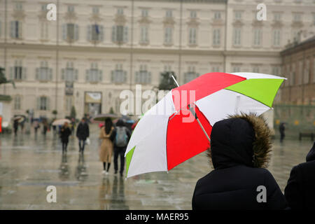 Les touristes avec parapluie dans les couleurs nationales italiennes sur la Piazza Castello, Turin, Italie, la marche vers le Palazzo Reale (Palais Royal). Banque D'Images