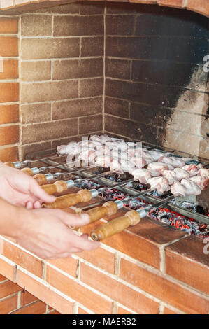 Mains courantes brochettes avec un délicieux, juteux, kebab fried à la broche cuit au feu dans un four à pierres. Le cadre vertical. Banque D'Images